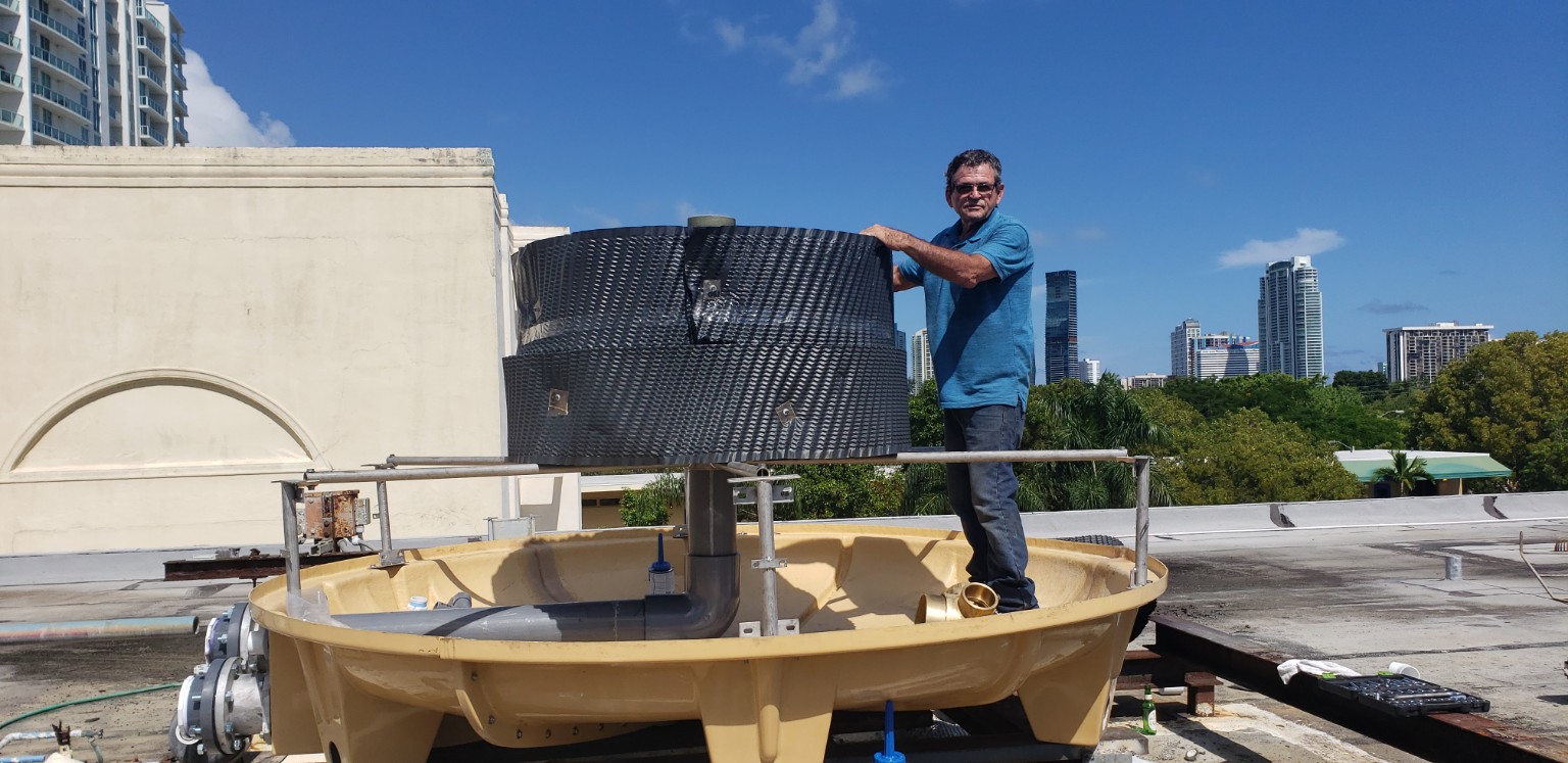 Technician servicing an opened cooling tower with internal fill media exposed