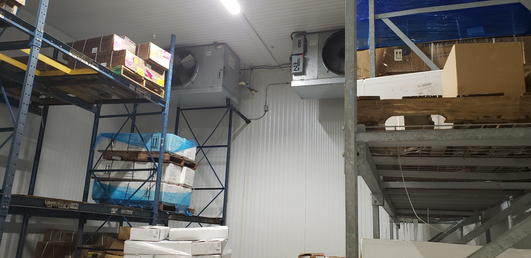 Multiple ceiling-mounted unit coolers serving a commercial cold-storage facility