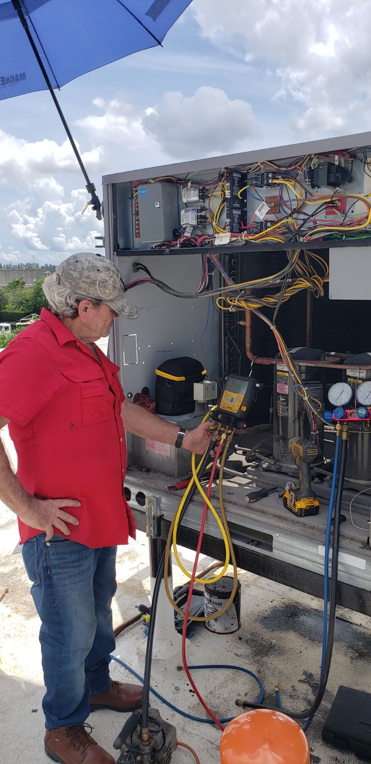 Technician performing commercial HVAC/R field service with refrigeration diagnostic instruments